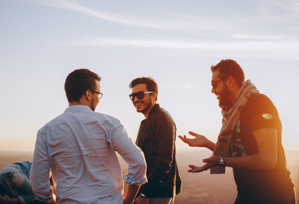 Group of male friends laughing together outdoors during sunset in Brazil.